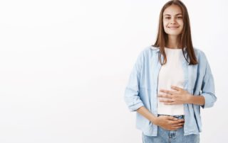 Mujer con las manos en el estómago y vientre.