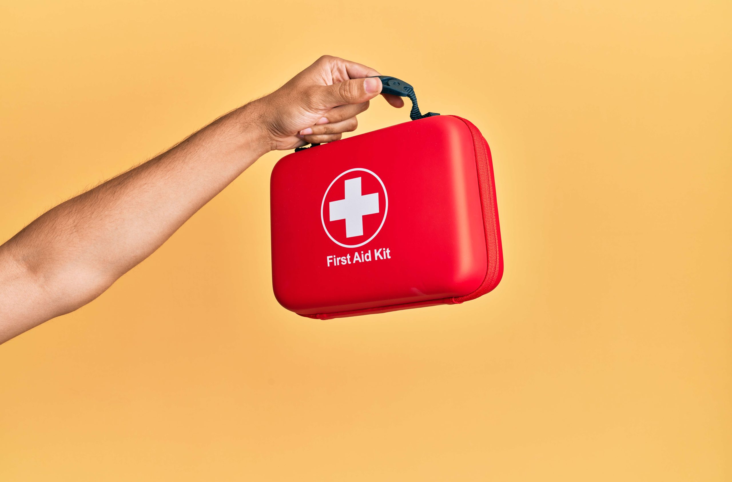 Mano sosteniendo botiquín de emergencias.
